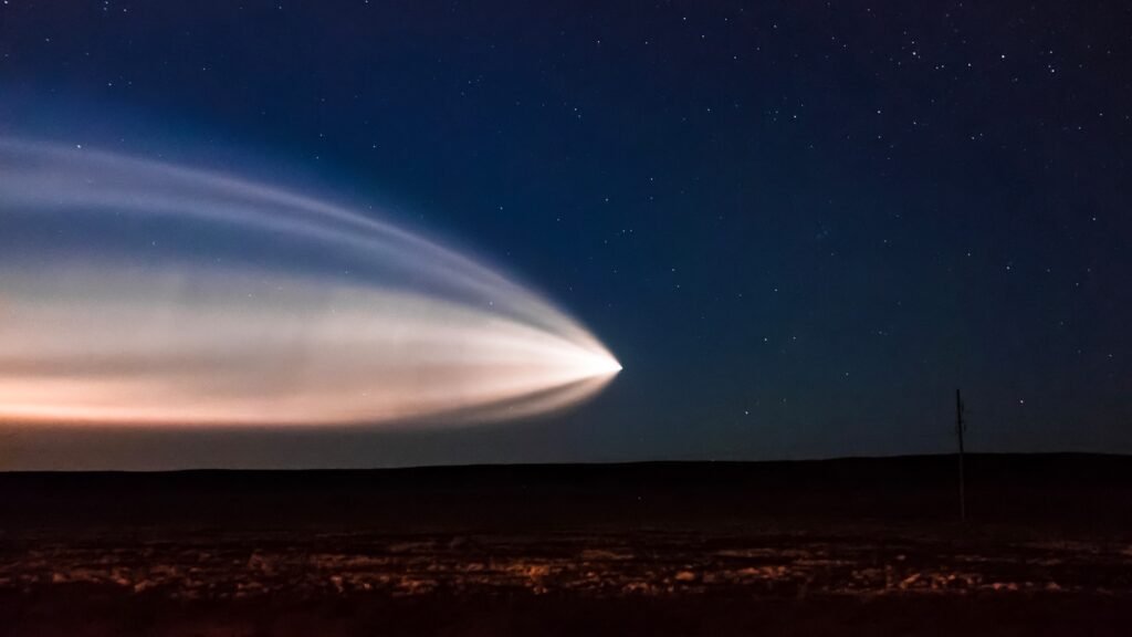 Start rakety Falcon 9 vynášející družice Starlink na noční obloze, světelná stopa letu